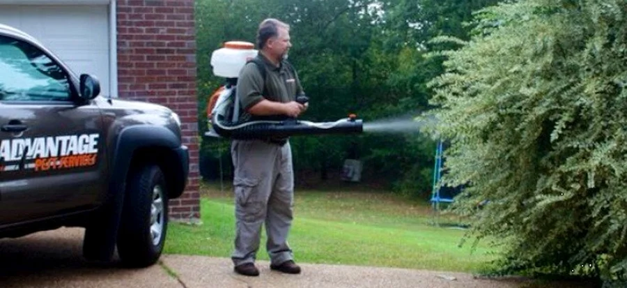 David McNeece treating a Madison MS yard for mosquitoes with a backpack fogger beside the APS truck